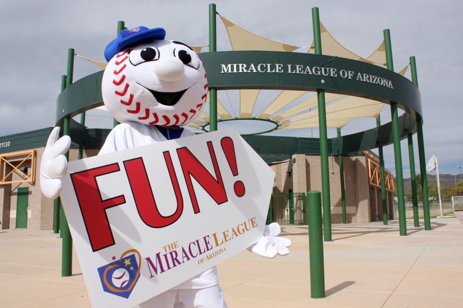 A baseball mascot holding a sign that says fun.