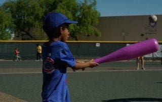 A young boy is playing baseball with a bat.