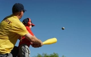 A man is hitting a ball with a baseball bat.