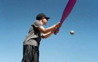 A young boy swinging a bat at a ball.