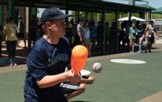A young boy is throwing a baseball to a crowd of people.