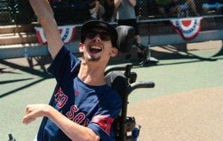 A man in a wheelchair celebrating at a baseball game.