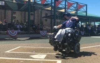 A man in a wheelchair on a baseball field.