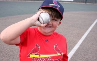A young boy holding a baseball in his hand.