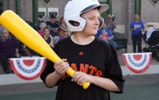 A young boy holding a baseball bat at a baseball game.