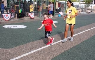 A woman and a young boy running on a track.