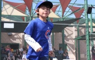 A young boy wearing a blue shirt and a baseball hat.
