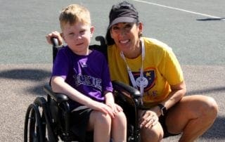 A woman in a wheelchair with a boy in a wheelchair.