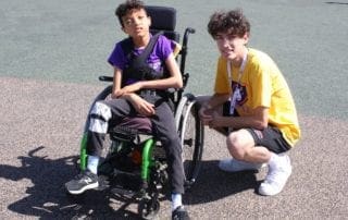 A boy in a wheelchair and a man in a wheelchair.