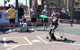 A group of people playing baseball with a person in a wheelchair.