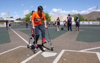 A boy in a wheelchair playing baseball on a field.