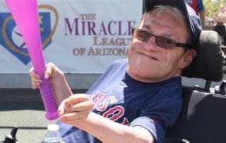 A man holding a purple baseball bat.