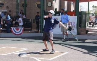 A boy is swinging a baseball bat.