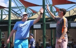 Two men giving each other high fives at a baseball game.