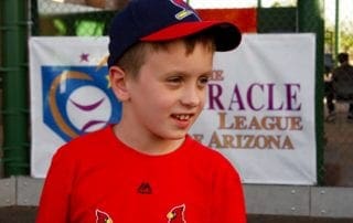 A young boy wearing a red baseball hat.