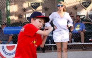 A young boy swinging a bat at a baseball game.