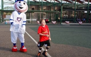 A boy is standing next to a mascot.