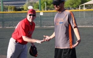 Two men shaking hands on a baseball field.