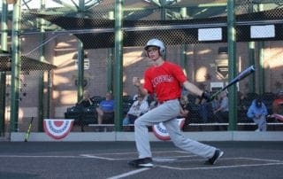 A young man swinging a baseball bat.