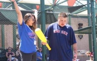 A man and woman standing next to each other holding a bat.