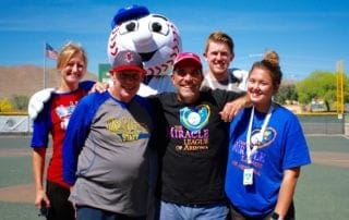 A group of people posing for a photo with a baseball mascot.