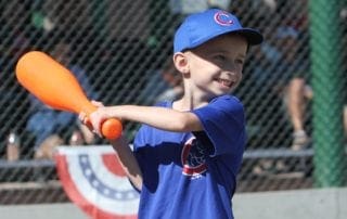 A young boy swinging a bat at a baseball game.