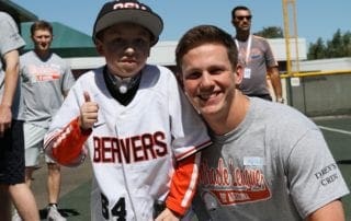A young boy is posing for a photo with a baseball player.