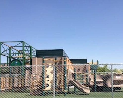 A playground with a chain link fence.