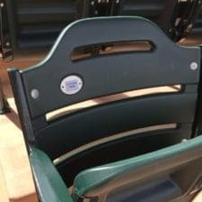A row of green seats in a baseball stadium.