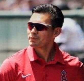 A baseball player wearing sunglasses and a red shirt.