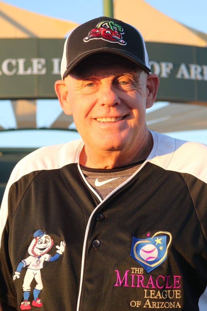 A man in a baseball uniform smiles for the camera.