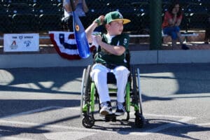A boy in a wheelchair holding a flag.