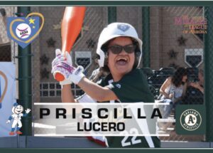 A smiling girl swings a bat at a baseball game.