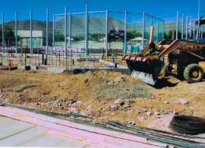 Construction site with backhoe and rebar.