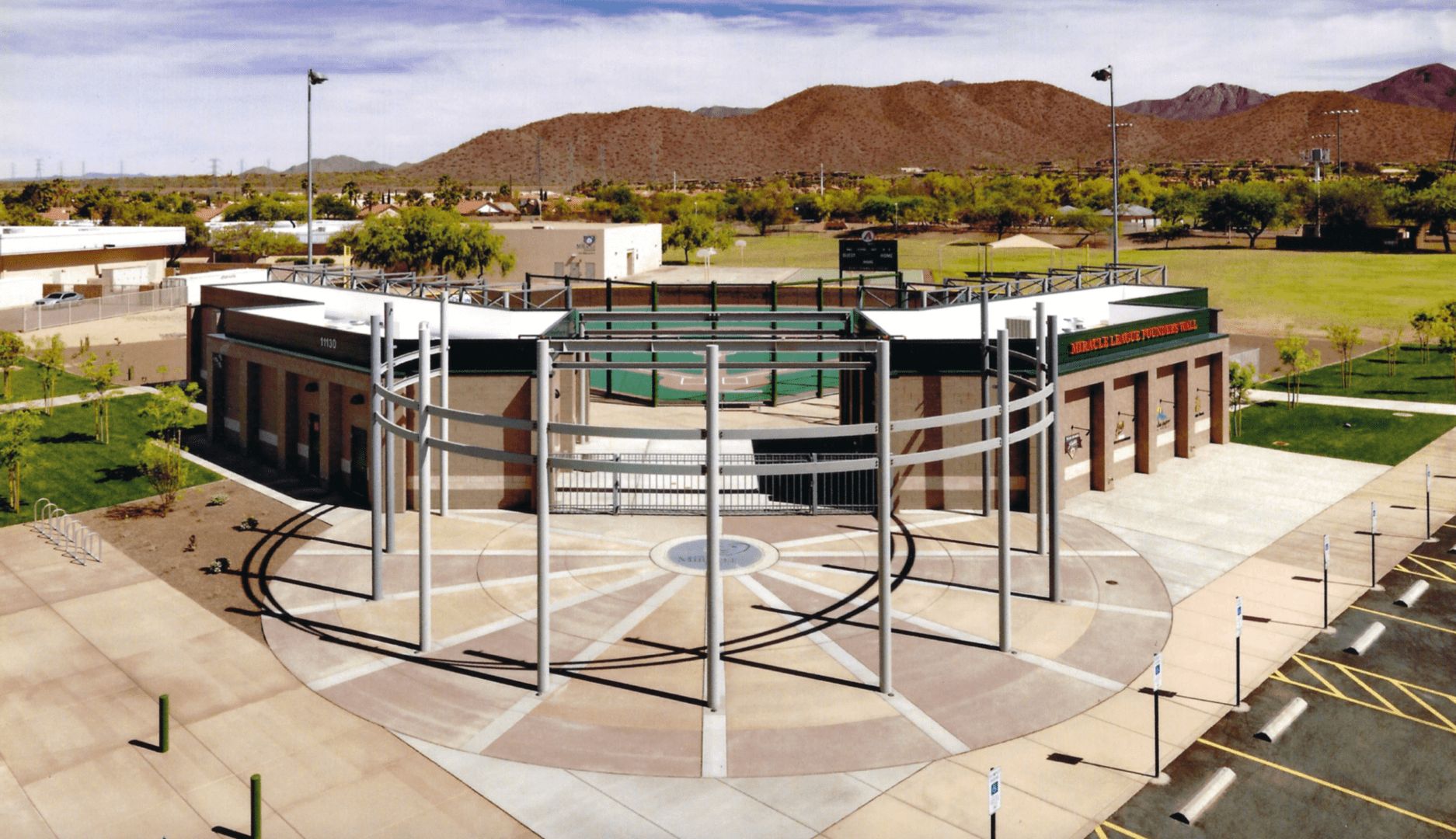 An aerial view of a baseball stadium with mountains in the background.