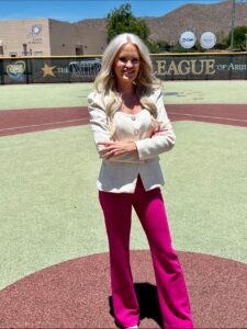 Woman in white blazer and pink pants.